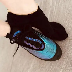 Lady Samanthas Füsse, einer in einer schwarzen Socke mit Kettchen, der andere in einem glänzenden, metallic-blauen Sneaker - Fussfetisch Zürich